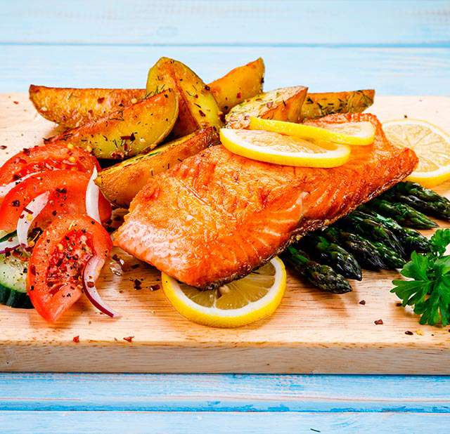 Fried salmon with potato slices and salad